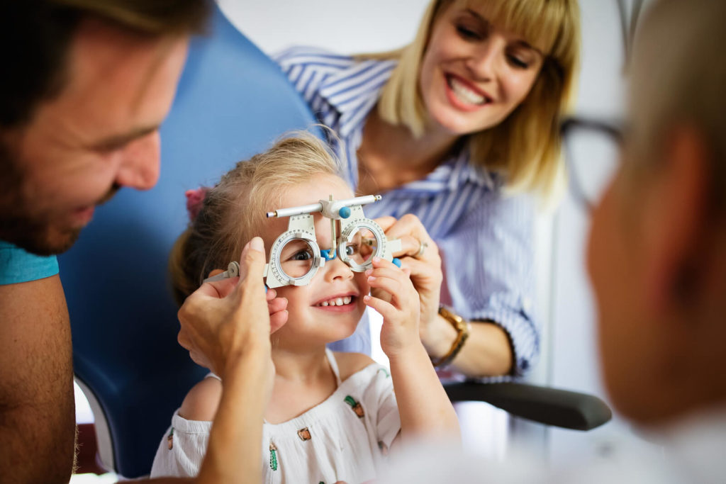 Child and parents eye exam with optometrist